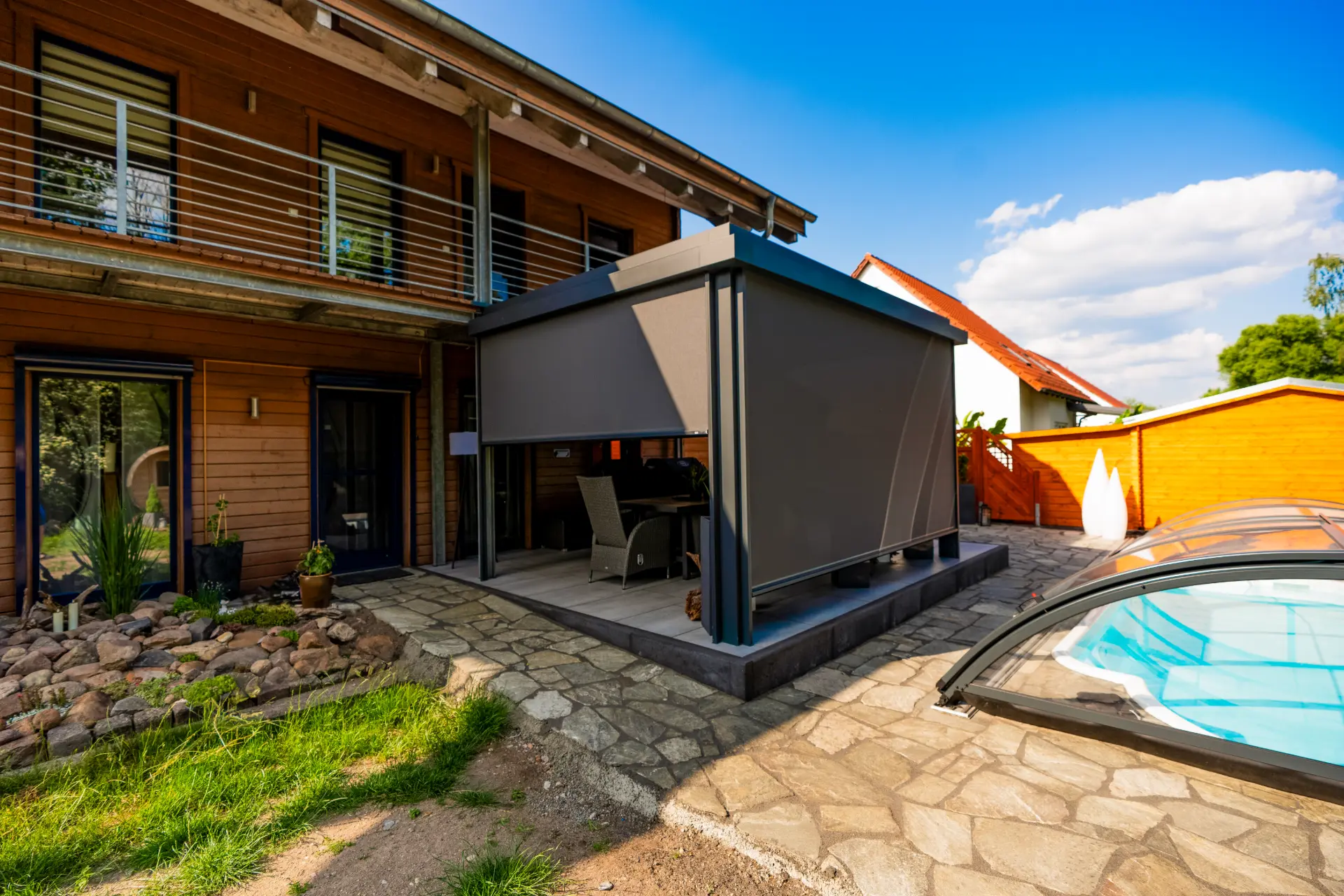 Terrassendach mit vollständig geschlossenen grauen Zip-Screens an einem Pool