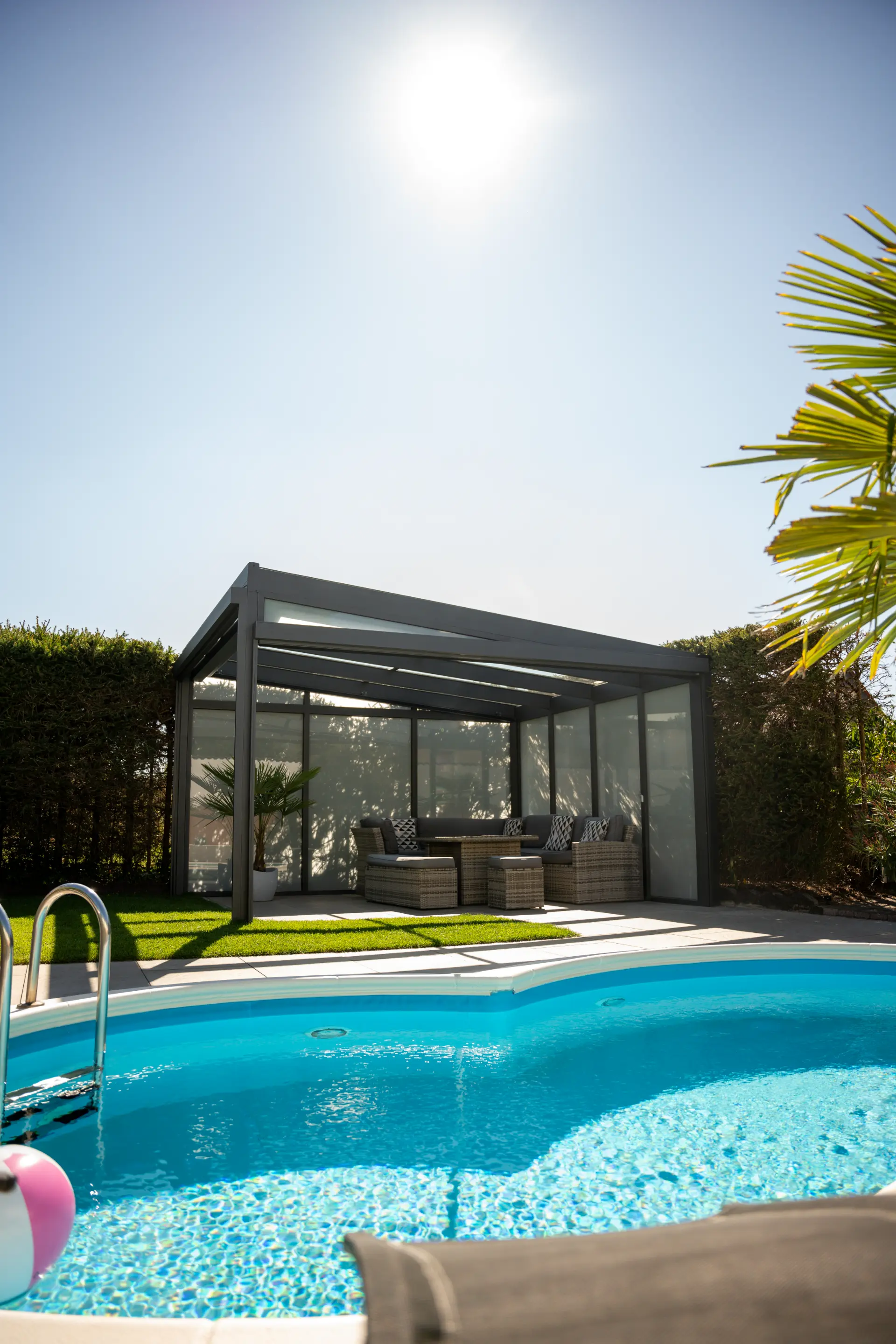 Freistehende Glasveranda mit geschlossenen Screens und Lounge-Sitzgruppe neben dem Pool