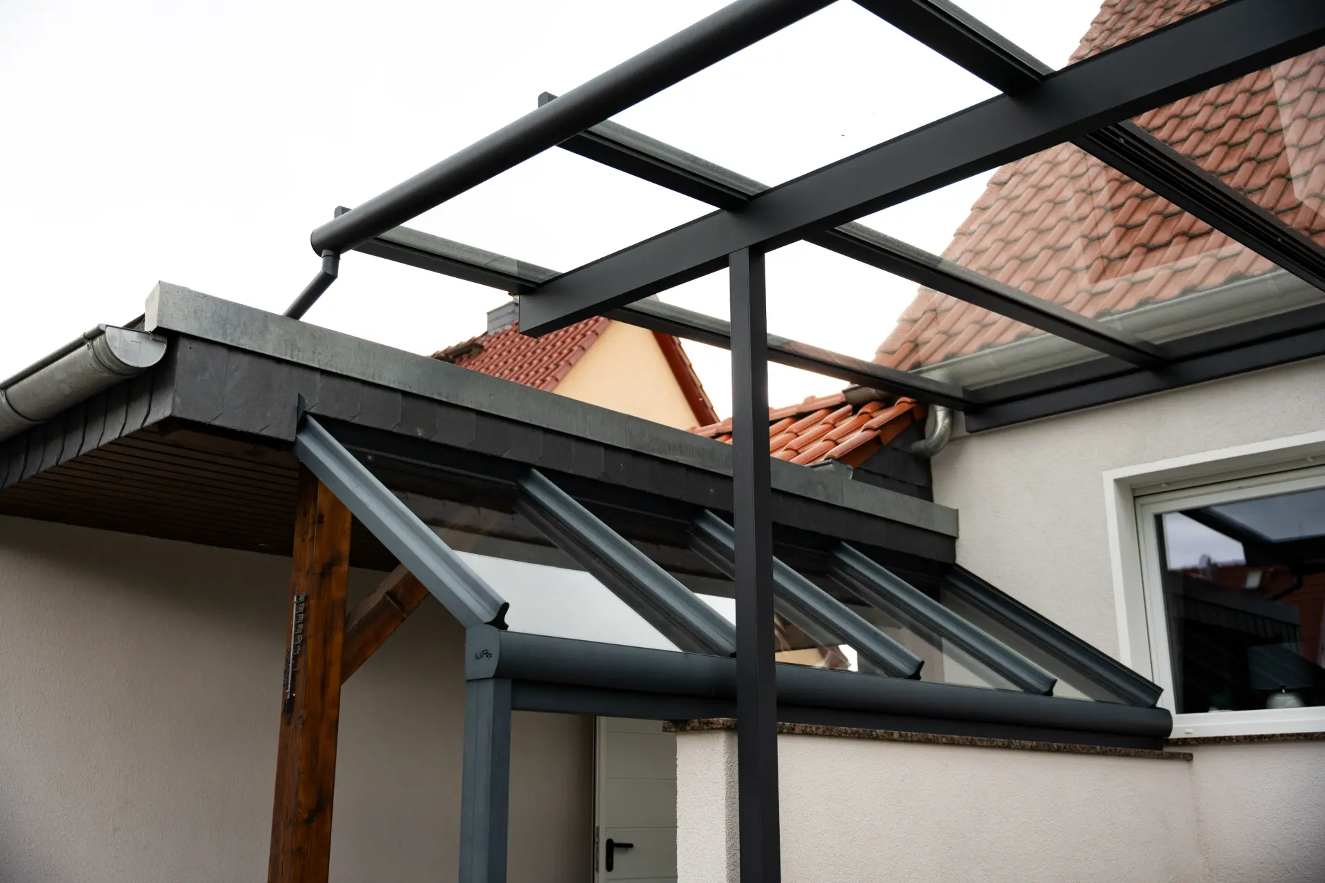 Nahaufnahme der Terrassendach-Konstruktion mit Holzsparren und Aluminiumprofilen